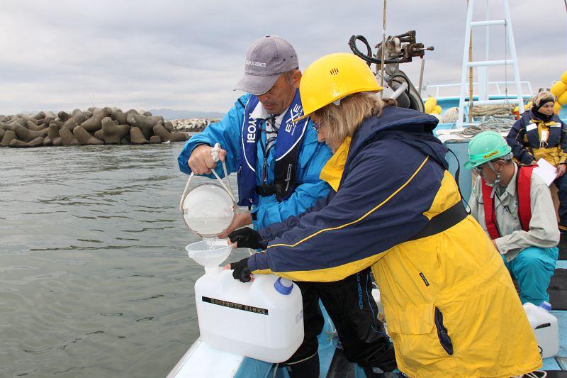Sabine Charmasson, chercheuse en radioécologie au Laboratoire d'études radioécologiques en milieu continental et marin (LERCM), et l'équipe du l'Institute of Environmental Radioactivity de l'Université de Fukushima, filtrent l'eau de mer prélevée.Au fond à droite, Mirelle Arnaud, chercheuse au LERCM  - © Médiathèque IRSN